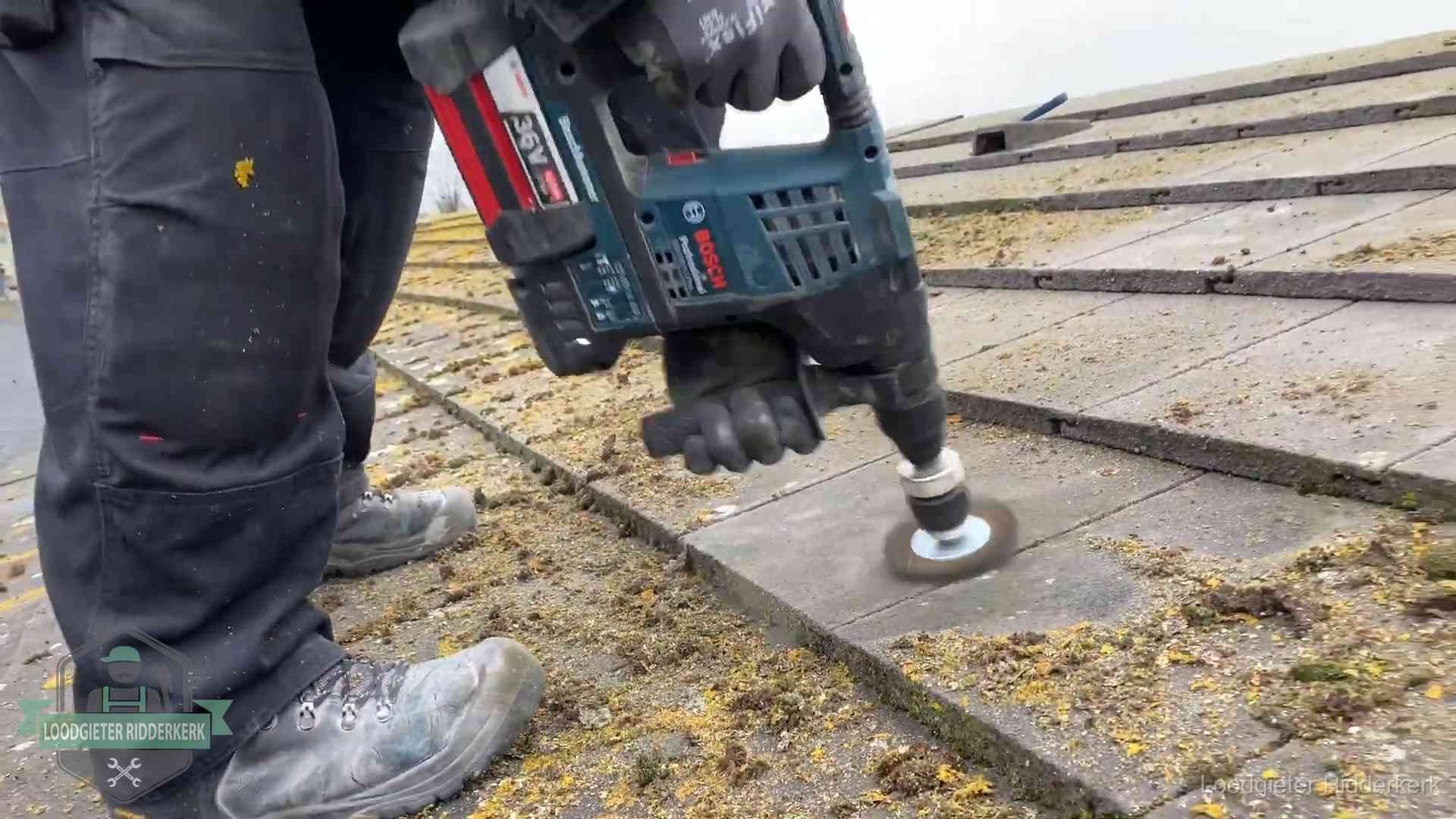 Betonnen dakpannen worden machinaal gereinigd tijdens dakonderhoud in Ridderkerk