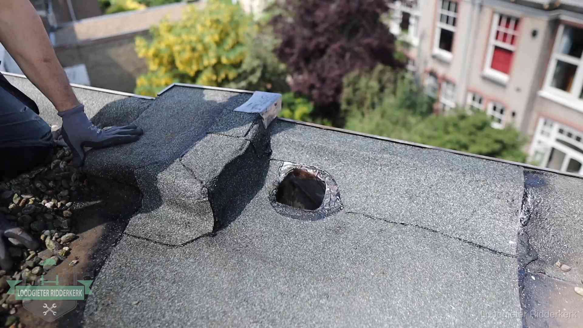 Loodgieter inspecteert een beschadigd bitumen plat dak tijdens een daklekkage-inspectie in Ridderkerk