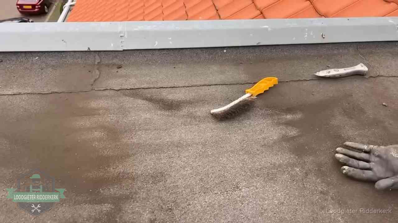 Dakdekker bereidt een bitumen plat dak voor op reparatie bij de daktrim in Ridderkerk