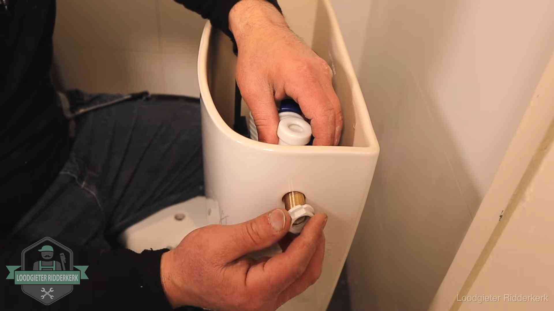 Loodgieter monteert de vlotterkraan van een stortbak bij een toilet in Ridderkerk