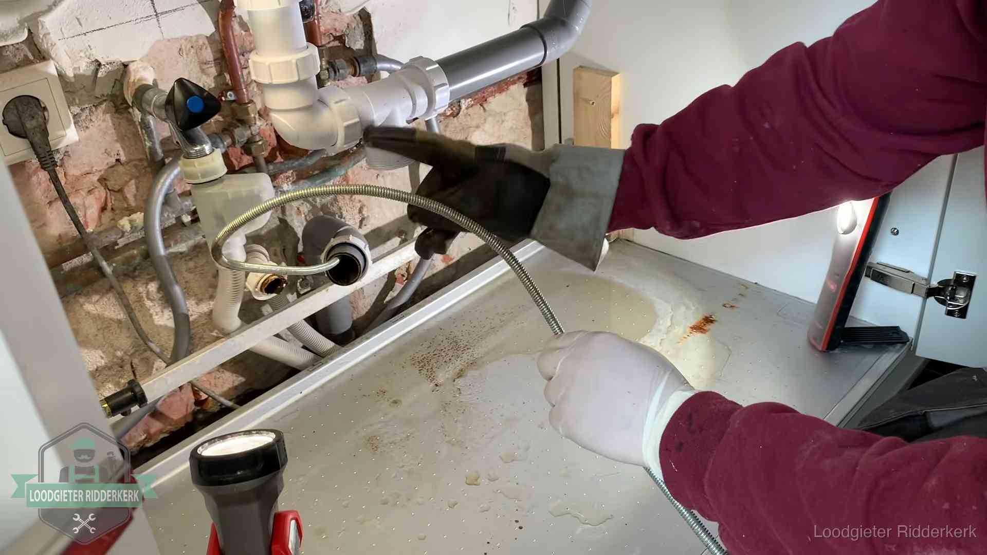 Spiraal of hogedruk in Ridderkerk Ontstoppingsveer gaat in een geopende sifonaansluiting onder het aanrecht in Ridderkerk