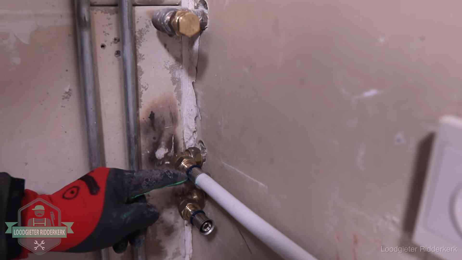 Garantie op loodgieterswerk in Ridderkerk Loodgieter wijst de persfitting op nieuwe muuraansluitingen aan in een woning in Ridderkerk
