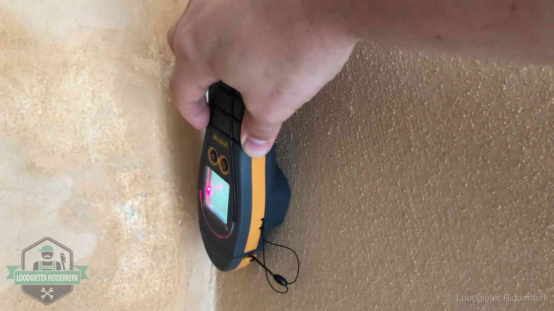 Vochtmeter tegen een muur met vochtplekken tijdens het opsporen van een daklekkage in Ridderkerk