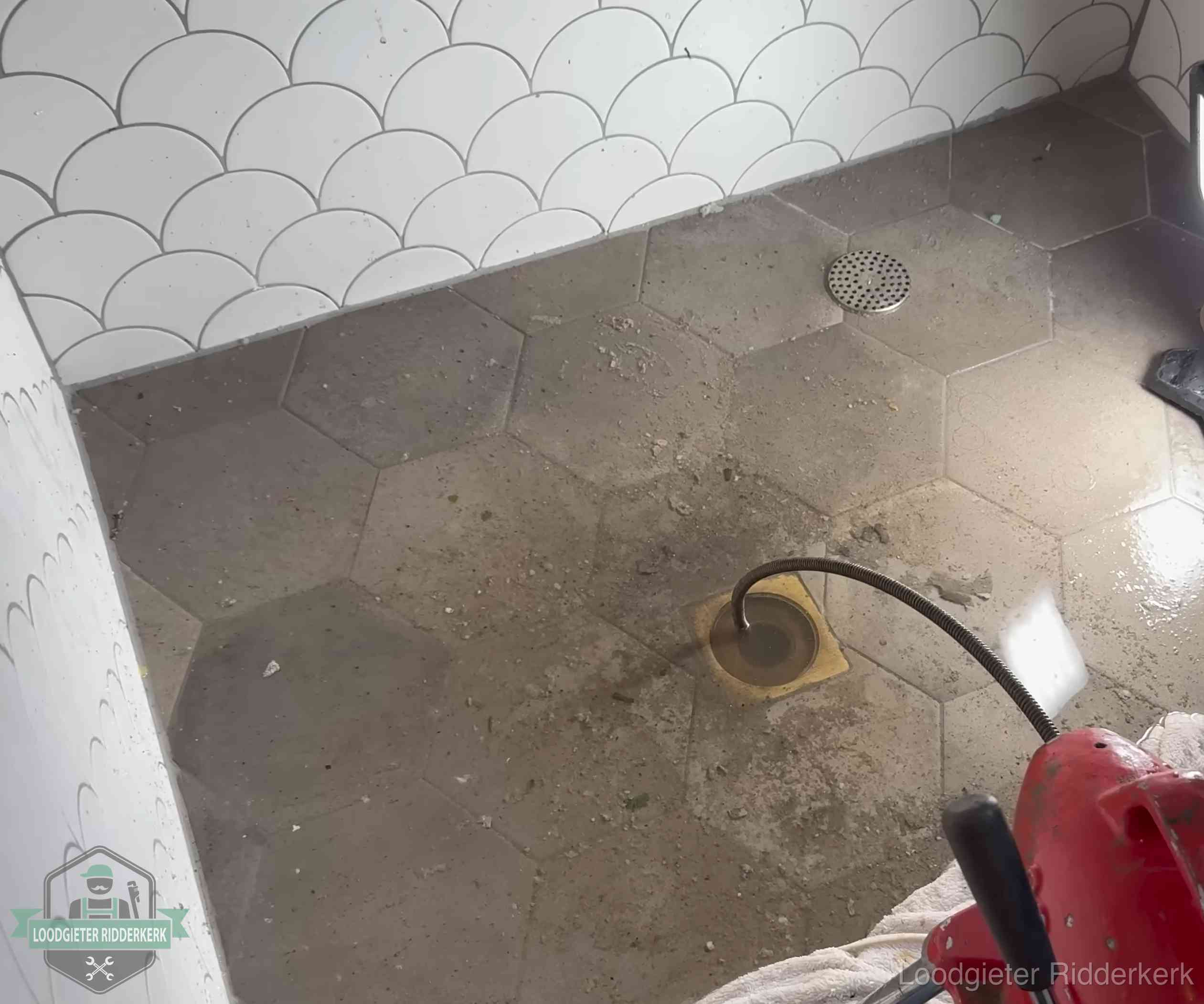 Vloerput met waterslot in een badkamer in Ridderkerk, een bron van stank als het waterslot droogstaat