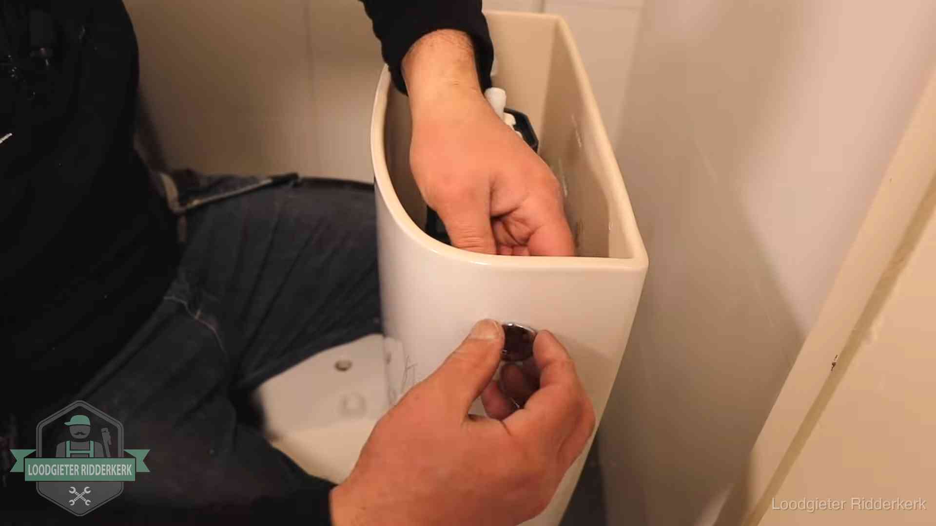 Drukknop van een duoblok-stortbak wordt gemonteerd bij een toilet in Ridderkerk