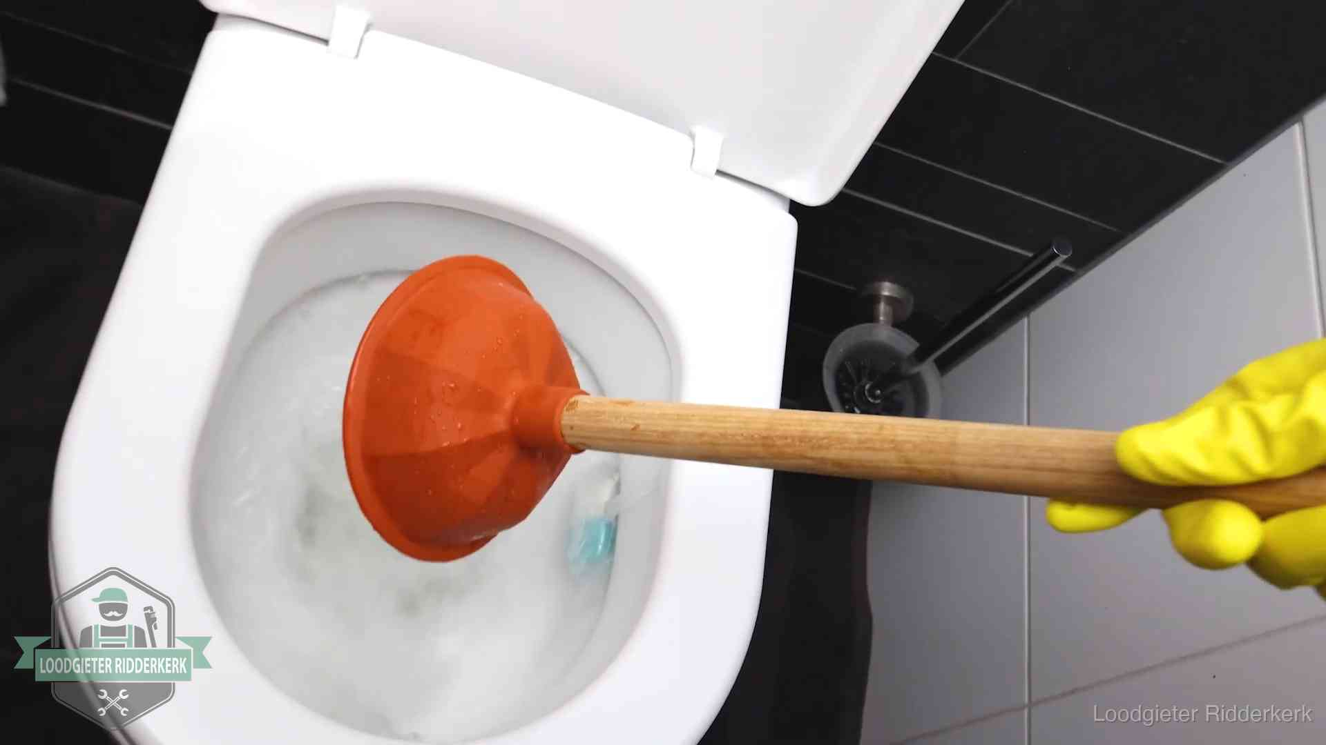 Plopper wordt in de wc-pot gedrukt bij het ontstoppen van een toilet in Ridderkerk