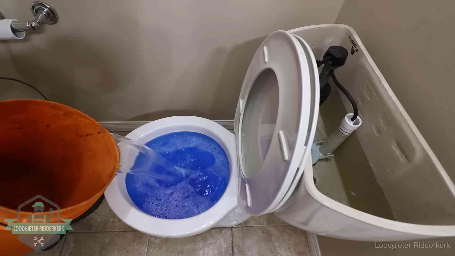 Water bij de wc-pot wordt met een emmer weggewerkt om schade te beperken in Ridderkerk